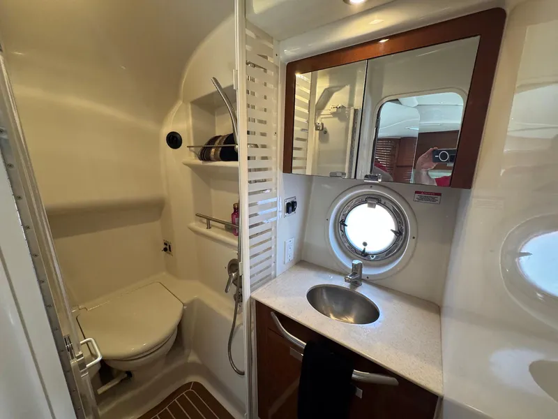 Slide: The Image of Luxurious bathroom in 2008 Sea Ray 350 Sundancer yacht with sink, mirror, and porthole window. - 32