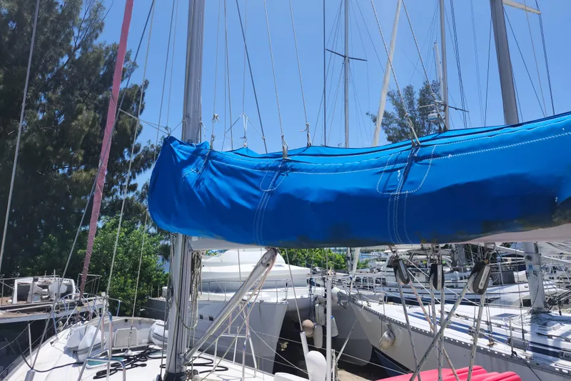 Slide: The Image of 2003 Beneteau 50 sailboat with blue sail cover, docked in marina. - 10