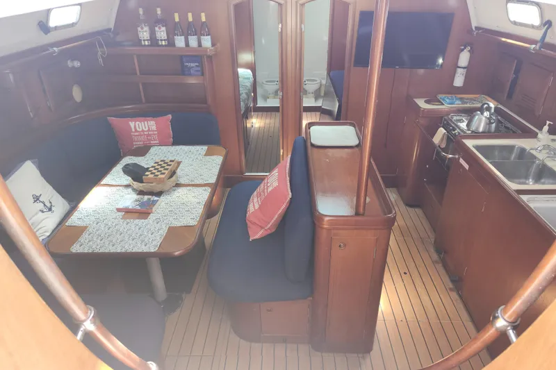Slide: The Image of Interior of 2003 Beneteau 50 yacht with dining area, kitchen, and cozy seating. - 23