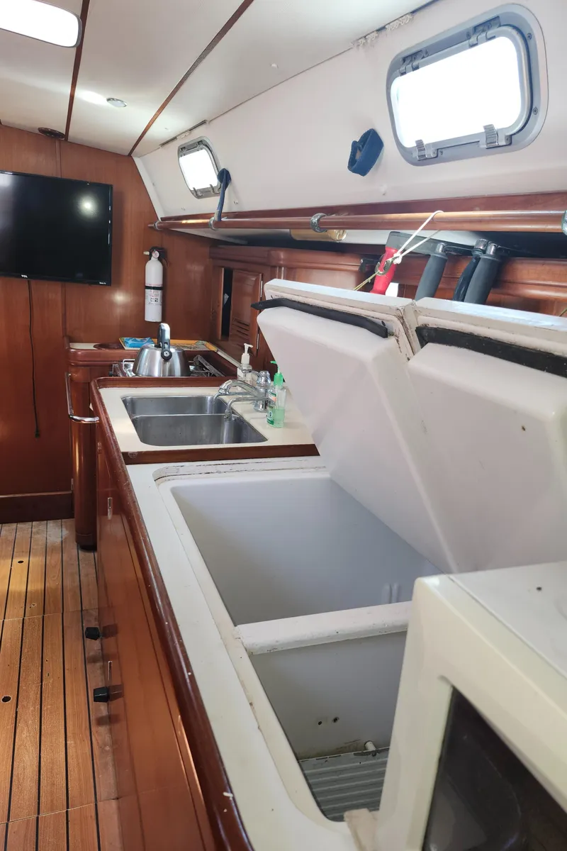 Slide: The Image of Interior of 2003 Beneteau 50 yacht kitchen with sink, open fridge, and wooden flooring. - 24