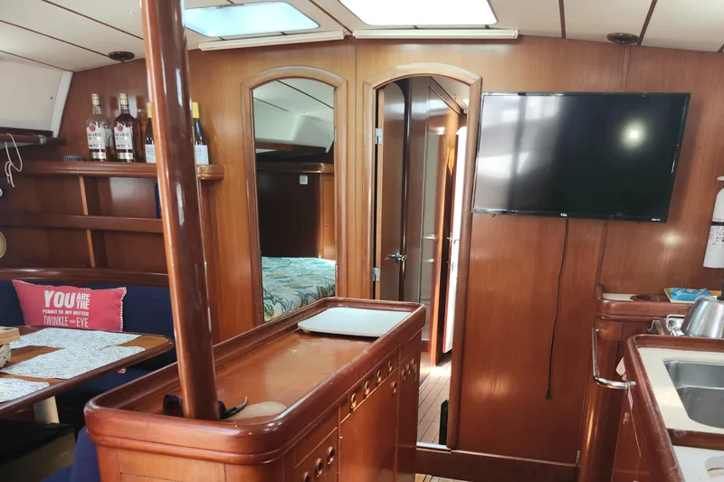 Slide: The Image of Interior of 2003 Beneteau 50 yacht with wood finish, TV, and cozy seating area. - 25