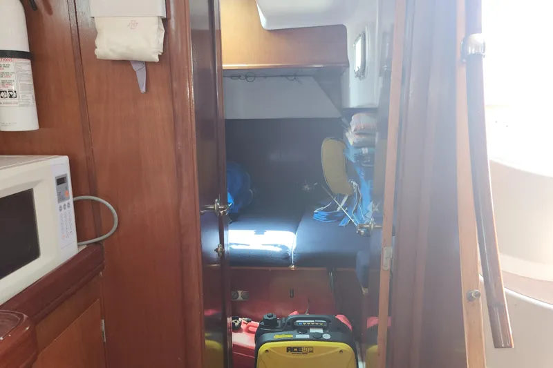 Slide: The Image of Interior of 2003 Beneteau 50 sailboat with microwave and storage area. - 29