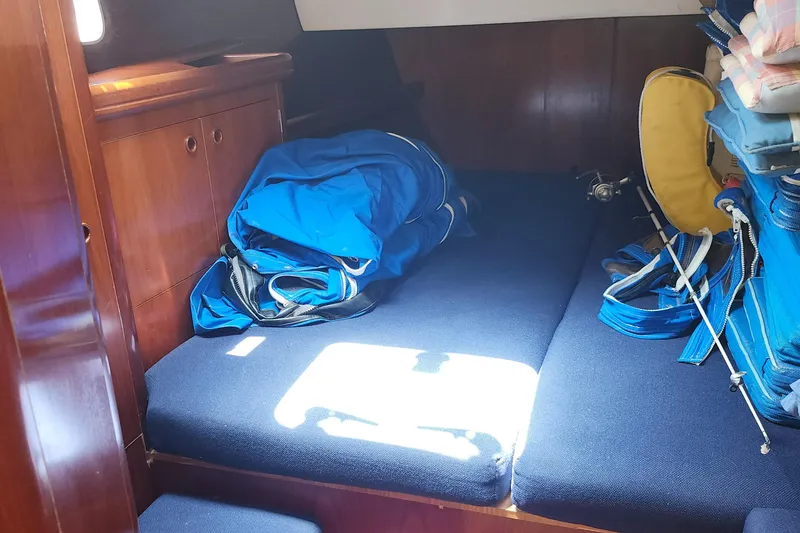 Slide: The Image of Interior cabin of 2003 Beneteau 50 sailboat with blue cushions and storage. - 31