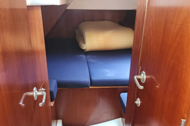 Slide: The Image of Cozy cabin interior of 2003 Beneteau 50 sailboat with blue cushions and wooden finish. - 33