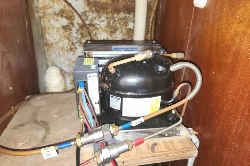 Slide: The Image of Compressor unit inside a 2003 Beneteau 50 yacht, showing wiring and tubing connections. - 40