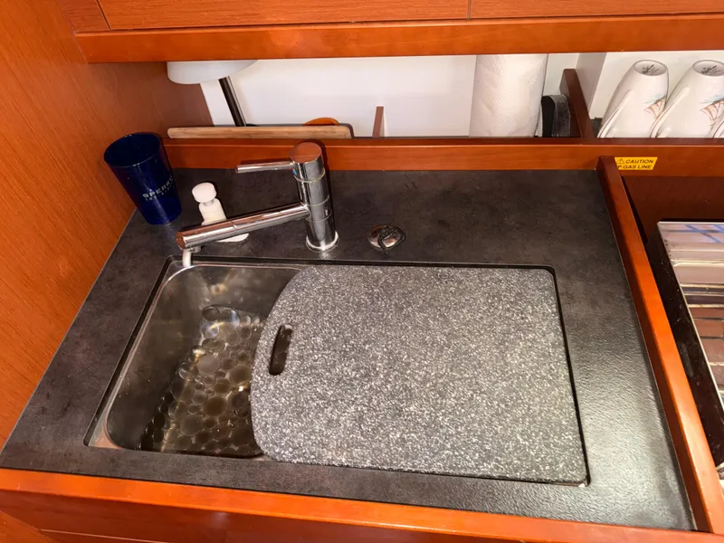 Slide: The Image of 2016 Beneteau Oceanis 45 yacht kitchen sink with cutting board and faucet. - 12