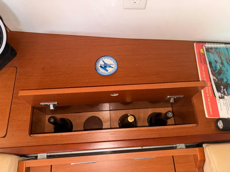 Slide: The Image of Wooden storage compartment on 2016 Beneteau Oceanis 45 yacht, holding wine bottles. - 13