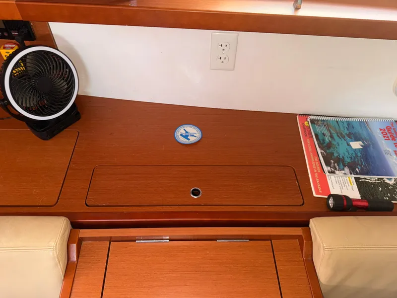 Slide: The Image of Interior of 2016 Beneteau Oceanis 45 yacht with fan, guidebook, and flashlight on wooden surface. - 14