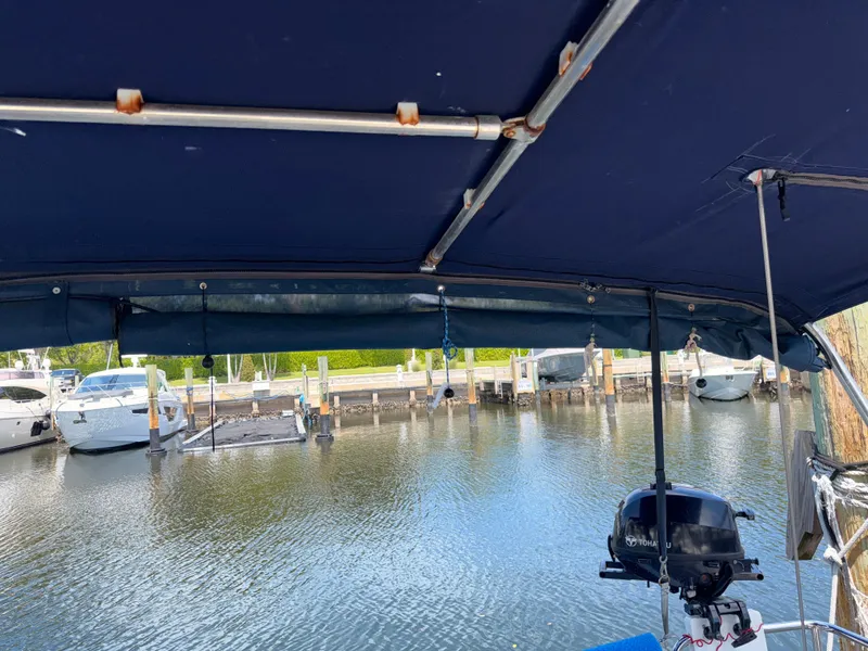 Slide: The Image of Beneteau Oceanis 45 (2016) docked, view from under blue canopy, marina background. - 21