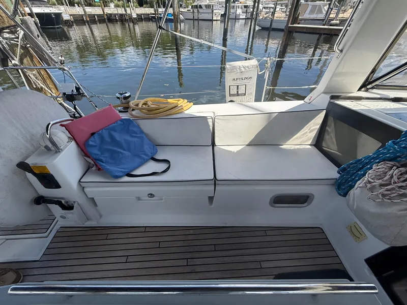 Slide: The Image of Cockpit of 2016 Beneteau Oceanis 45 sailboat with seating, ropes, and marina view. - 30