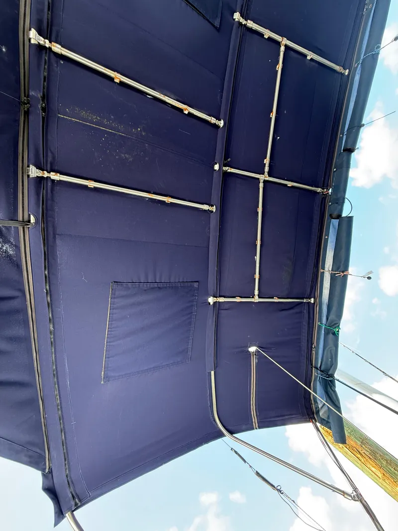 Slide: The Image of Blue canopy of a 2016 Beneteau Oceanis 45 sailboat, featuring metal support rods. - 31