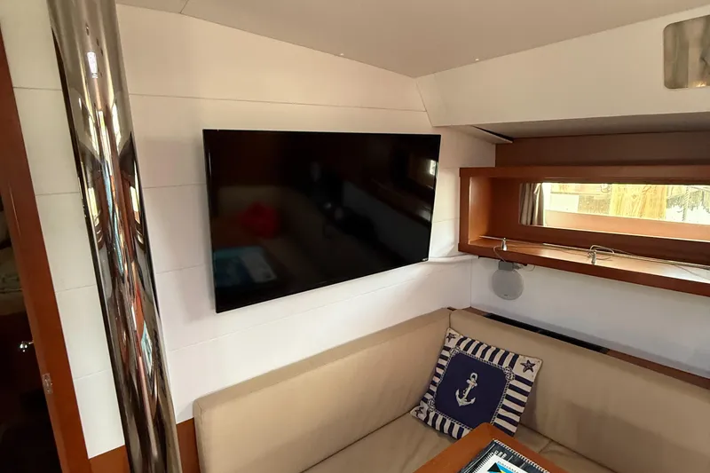 Slide: The Image of Interior of 2016 Beneteau Oceanis 45 yacht with TV and nautical-themed decor. - 45