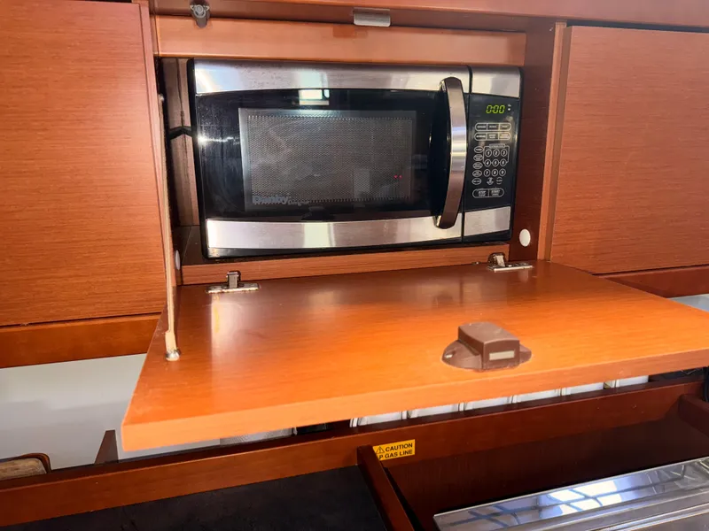 Slide: The Image of Microwave in 2016 Beneteau Oceanis 45 yacht kitchen, with wooden cabinetry. - 7