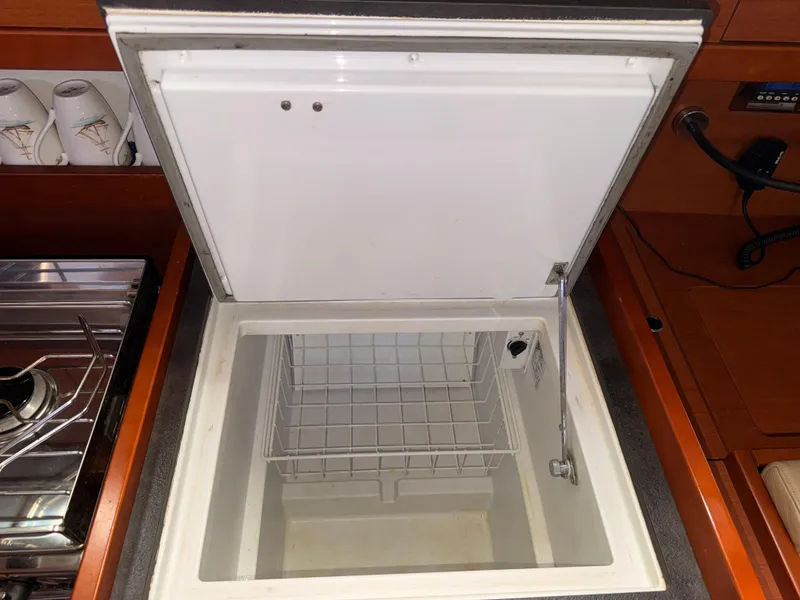 Slide: The Image of Open refrigerator in 2016 Beneteau Oceanis 45 yacht kitchen, with stove and cups nearby. - 8