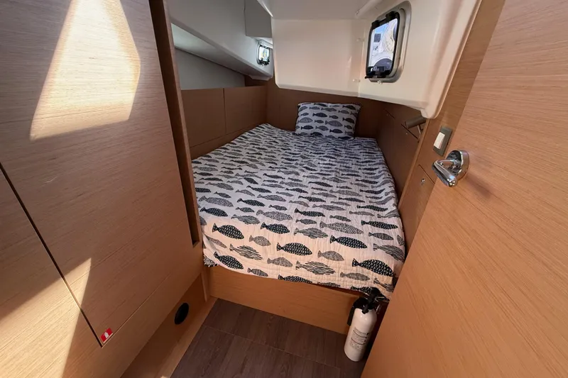 Slide: The Image of Cozy cabin interior of 2023 Jeanneau Sun Odyssey 410 sailboat with fish-patterned bedding. - 10