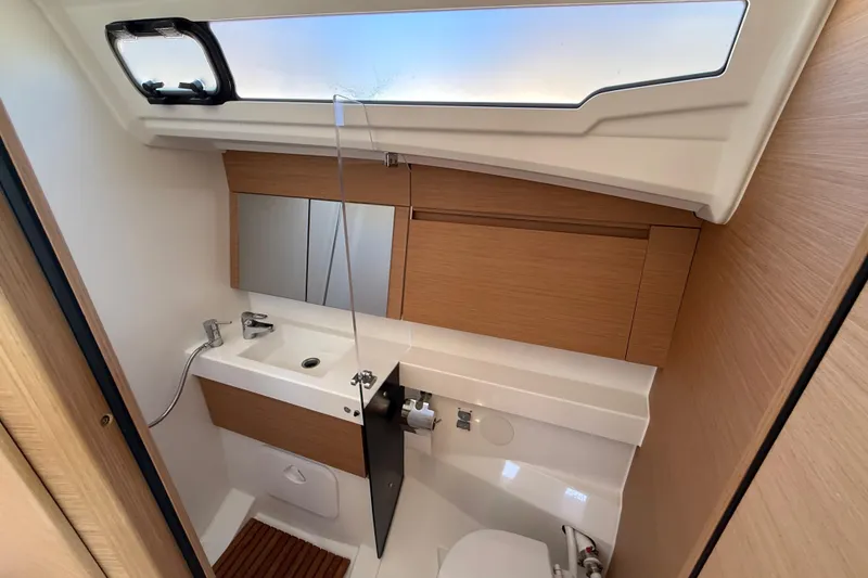 Slide: The Image of Modern bathroom interior of 2023 Jeanneau Sun Odyssey 410 yacht, featuring sleek design and wood accents. - 14
