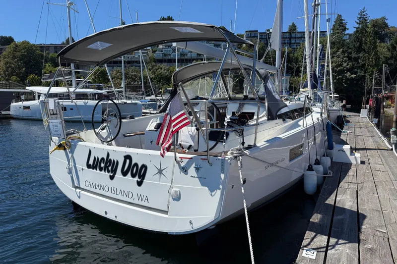 Slide: The Image of 2023 Jeanneau Sun Odyssey 410 sailboat docked, named "Lucky Dog," with American flag. - 22