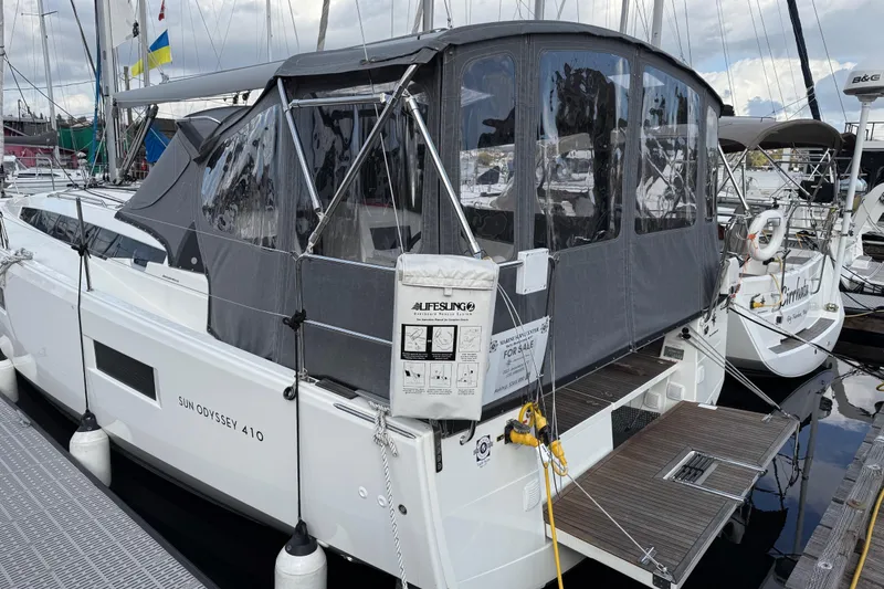Slide: The Image of 2023 Jeanneau Sun Odyssey 410 sailboat docked with protective canopy and equipment. - 25