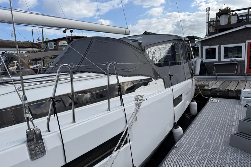 Slide: The Image of 2023 Jeanneau Sun Odyssey 410 sailboat docked, featuring sleek design and covered cockpit. - 30