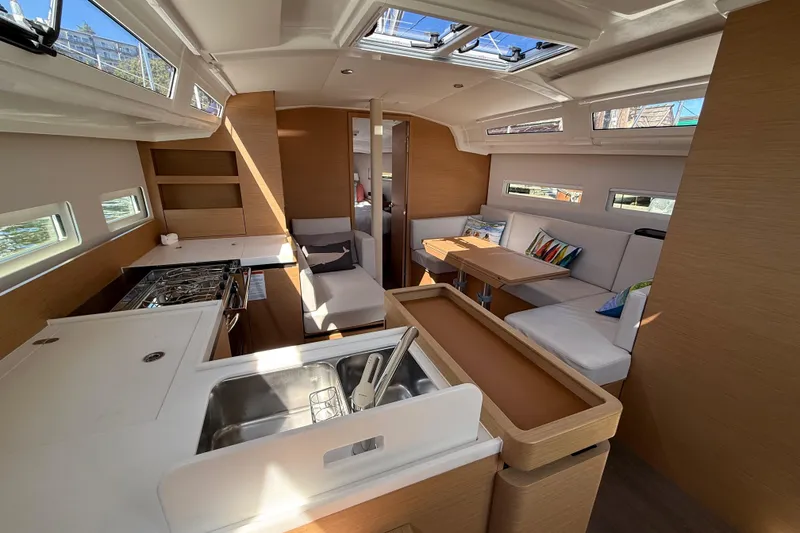 Slide: The Image of Interior of 2023 Jeanneau Sun Odyssey 410 yacht, featuring modern kitchen and seating area. - 4