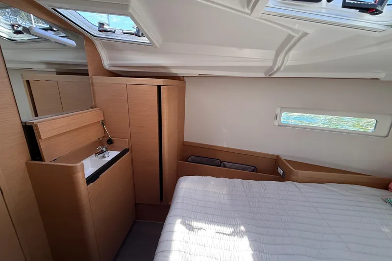 Slide: The Image of Interior of 2023 Jeanneau Sun Odyssey 410 yacht cabin with bed and wooden cabinetry. - 7
