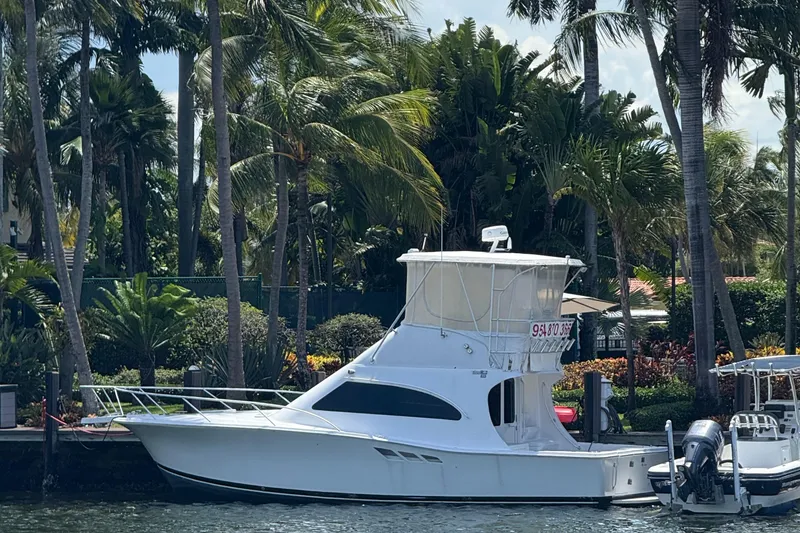 Slide: The Image of 2000 Luhrs Tournament 360 Convertible yacht docked by tropical palm trees. - 0