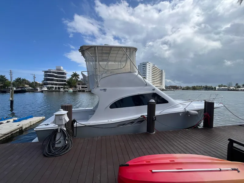 Slide: The Image of 2000 Luhrs Tournament 360 Convertible yacht docked by waterfront buildings. - 1