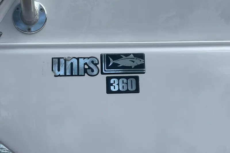 Slide: The Image of Luhrs Tournament 360 Convertible 2000 boat logo with fish emblem. - 104