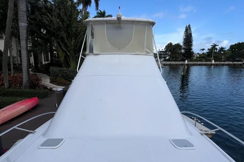 Slide: The Image of 2000 Luhrs Tournament 360 Convertible yacht docked by a scenic waterfront. - 11