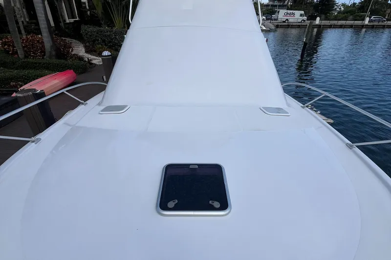 Slide: The Image of 2000 Luhrs Tournament 360 Convertible boat deck with hatch, docked by the water. - 12