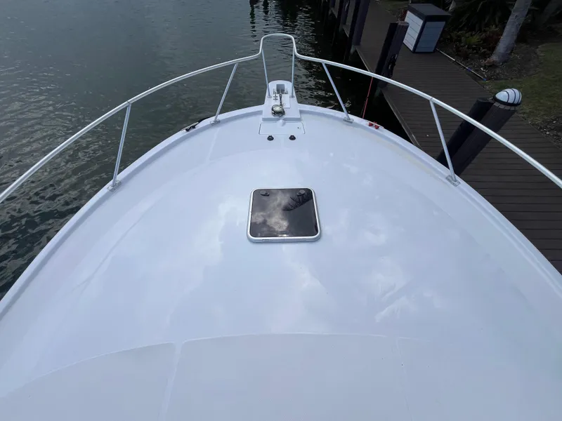 Slide: The Image of Bow view of 2000 Luhrs Tournament 360 Convertible boat docked by the water. - 13
