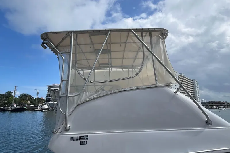 Slide: The Image of 2000 Luhrs Tournament 360 Convertible boat with enclosed flybridge, docked by waterfront buildings. - 17