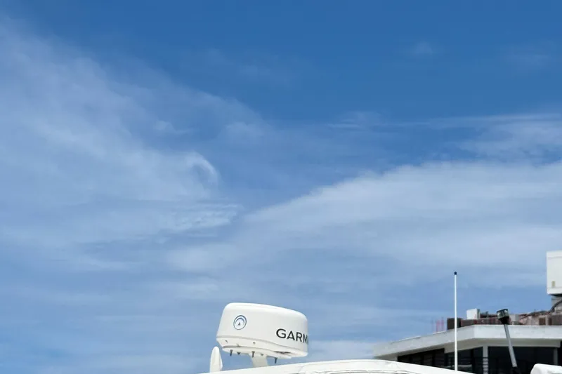 Slide: The Image of Luhrs Tournament 360 Convertible 2000 boat with Garmin radar under a clear blue sky. - 18