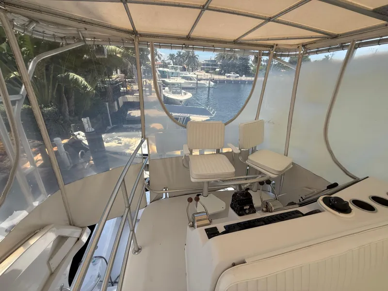 Slide: The Image of 2000 Luhrs Tournament 360 Convertible yacht helm with seating and marina view. - 28