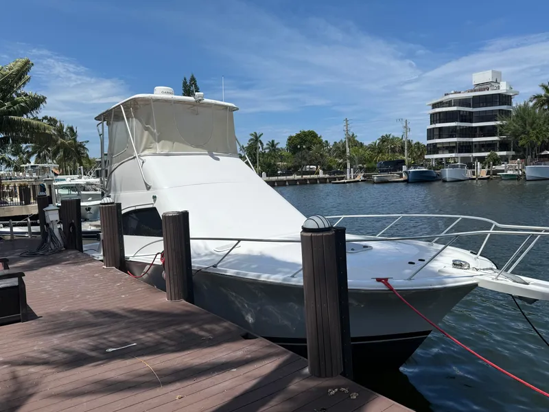 Slide: The Image of 2000 Luhrs Tournament 360 Convertible docked by a waterfront, surrounded by palm trees. - 5