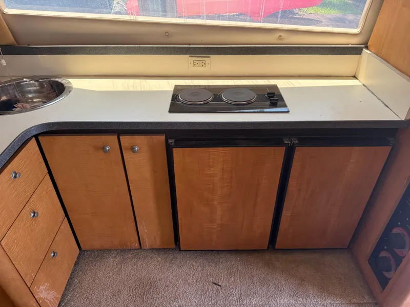 Slide: The Image of 2000 Luhrs Tournament 360 Convertible kitchen with stove, sink, and wooden cabinets. - 61