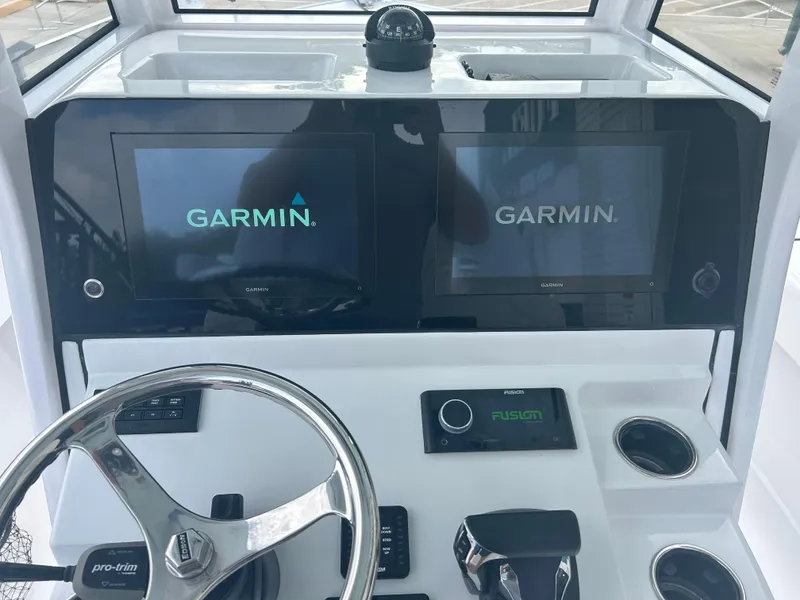 Slide: The Image of 2023 Sportsman Masters 267OE Bay Boat dashboard with Garmin displays and Fusion audio controls. - 31