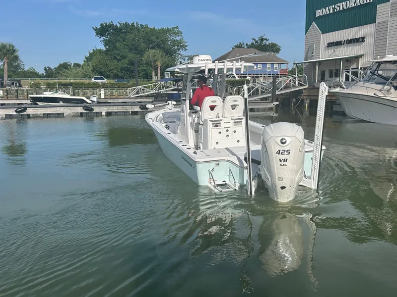Slide: The Image of 2023 Sportsman Masters 267OE Bay Boat docked at marina with outboard engine. - 4