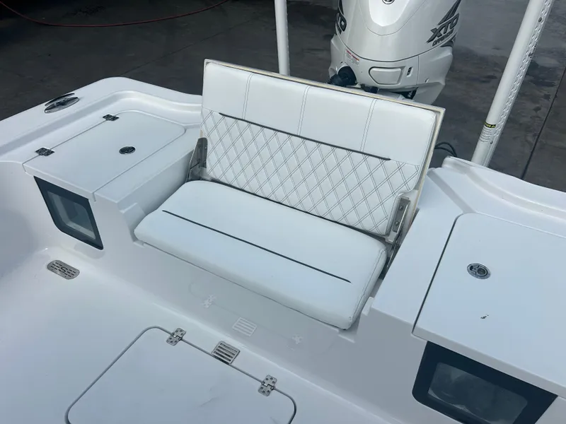 Slide: The Image of 2023 Sportsman Masters 267OE Bay Boat with white cushioned seating and storage compartments. - 46