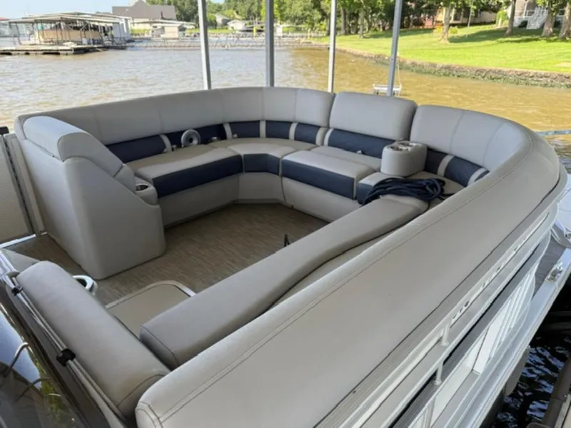 Slide: The Image of 2022 Bennington 23 LSB pontoon boat with spacious seating on a calm lake. - 7