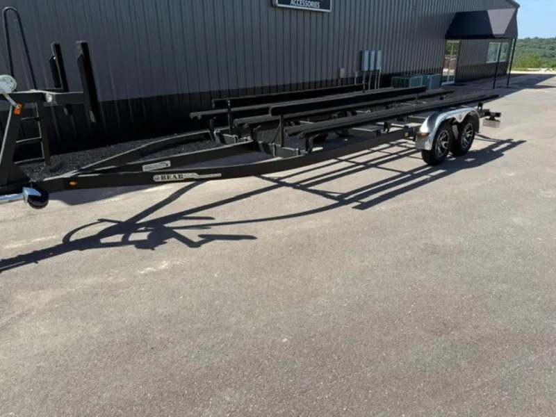 Slide: The Image of 2022 Bennington 23 LSB boat trailer parked on pavement near a building. - 8