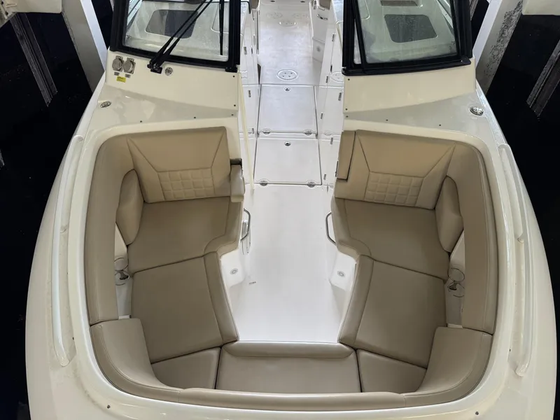 Slide: The Image of 2019 Everglades 340 Dual Console boat interior with beige seating and white deck. - 10