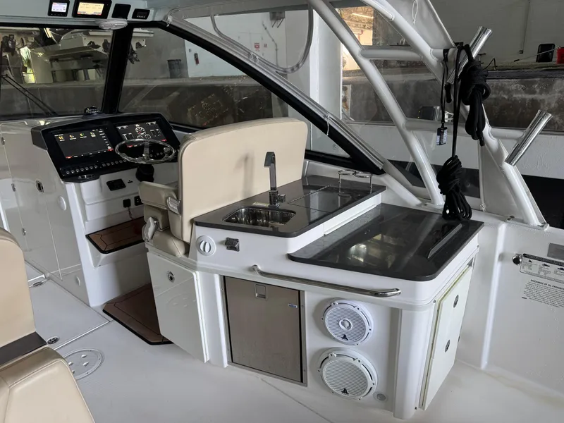 Slide: The Image of 2019 Everglades 340 Dual Console boat interior with helm, sink, and seating area. - 15