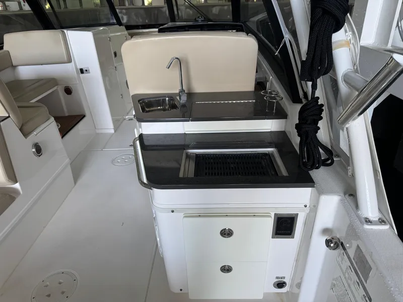 Slide: The Image of 2019 Everglades 340 Dual Console boat interior with sink and seating area. - 17