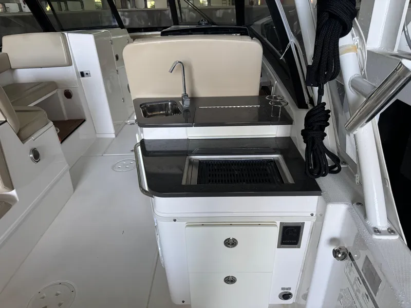Slide: The Image of 2019 Everglades 340 Dual Console boat interior with sink and seating area. - 18