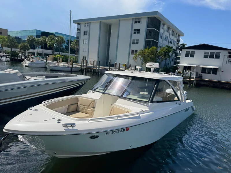 Slide: The Image of 2019 Everglades 340 Dual Console boat docked near waterfront buildings. - 22