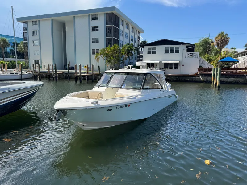 Slide: The Image of 2019 Everglades 340 Dual Console boat docked near waterfront buildings. - 23