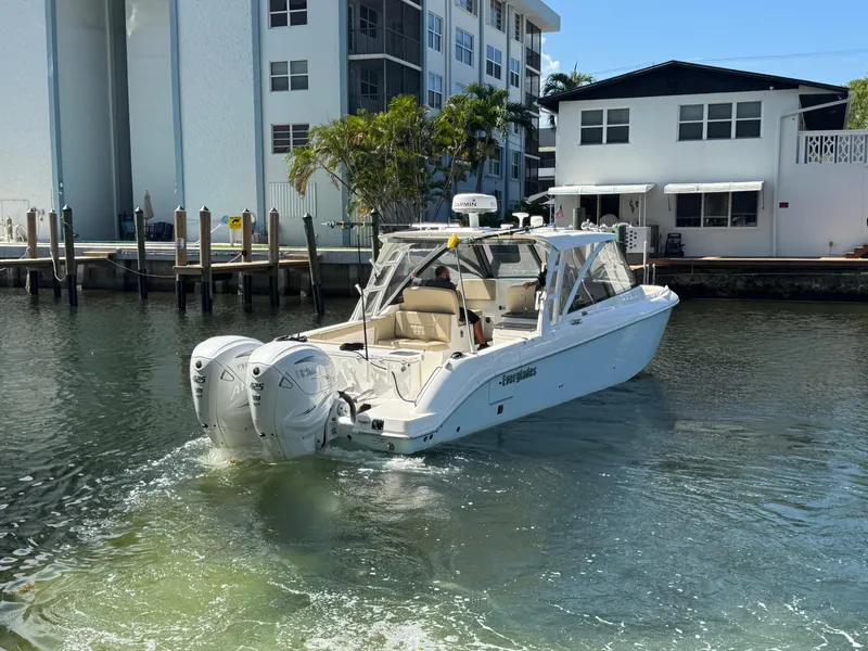 Slide: The Image of 2019 Everglades 340 Dual Console boat docked near waterfront buildings. - 28