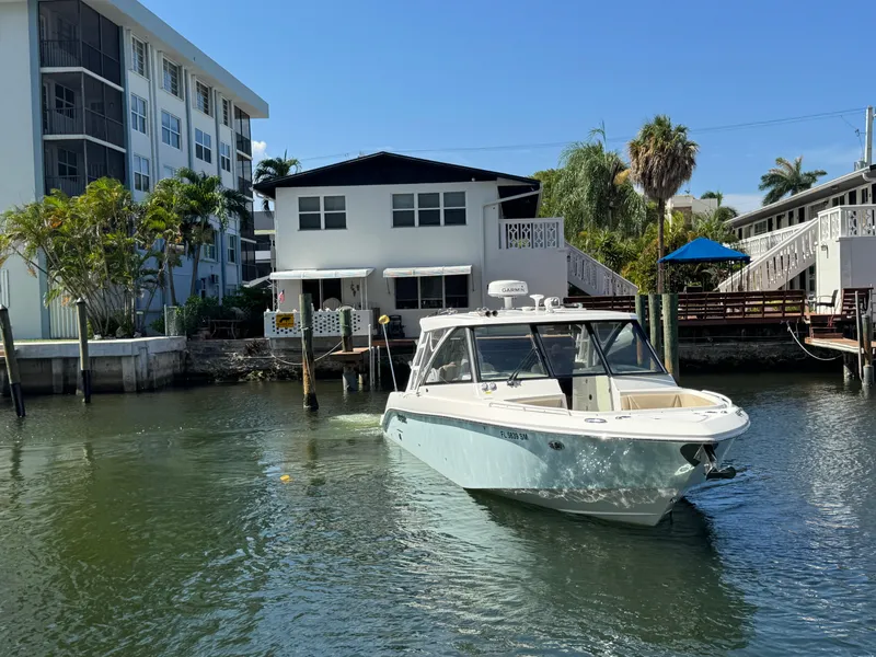 Slide: The Image of 2019 Everglades 340 Dual Console boat docked near waterfront homes. - 33