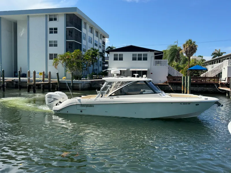 Slide: The Image of 2019 Everglades 340 Dual Console boat docked near waterfront buildings. - 38
